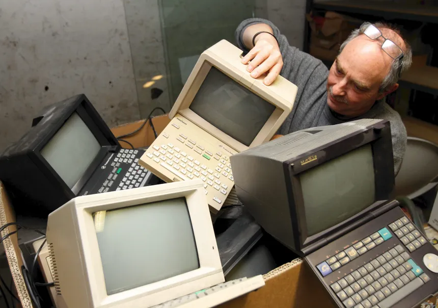 man struggling with all of his computers
